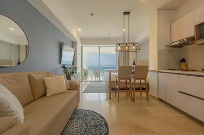 a living room and kitchen with a couch and a table at Condominio exclusivo nuevo frente al mar Cartagena Beach in Cartagena de Indias
