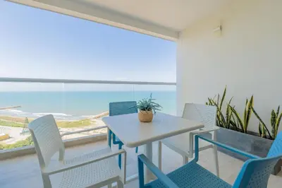 a table and chairs with a view of the ocean at Condominio exclusivo nuevo frente al mar Cartagena Beach in Cartagena de Indias