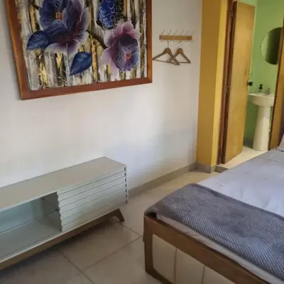 a bedroom with a bed and a table and a painting at Dreimar Hotel Boutique in Cartagena de Indias