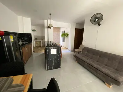 a living room with a couch and a clock on the wall at Apartamento Villa Mary-Coveñas in Coveñas