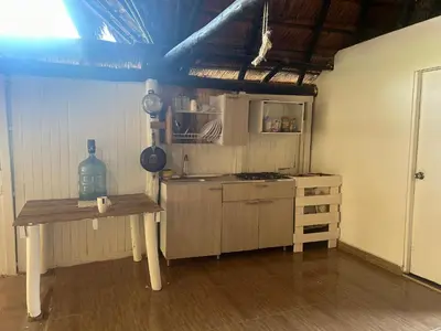 a kitchen with a table and a stove in a room at Punta Arena EcoHostal & EcoFit - Your Eco-Friendly Oasis 01 in Playa Punta Arena