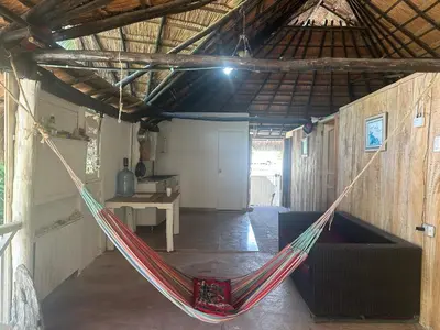 a hammock in a room in a barn at Punta Arena EcoHostal & EcoFit - Your Eco-Friendly Oasis 01 in Playa Punta Arena