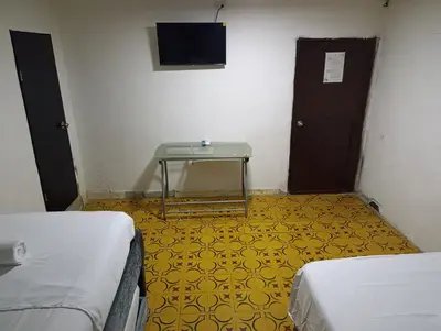 a room with two beds and a table and a tv at Casa vacacional, cerca del aeropuerto in Cartagena de Indias