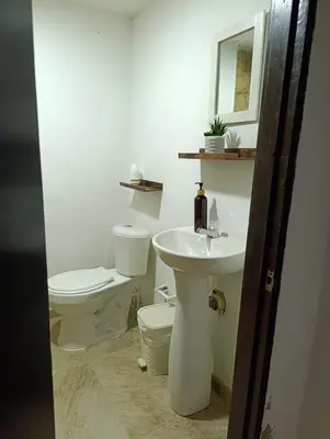 a white bathroom with a toilet and a sink at Casa vacacional, cerca del aeropuerto in Cartagena de Indias