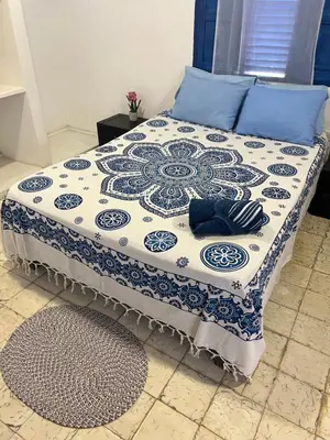a bed with a blue and white quilt on it at Belcanto Room's in Cartagena de Indias