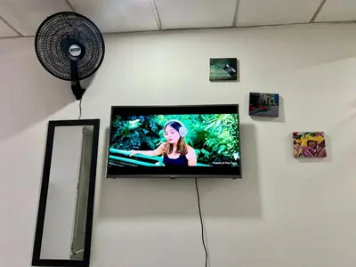 a flat screen tv on a wall with a fan at Belcanto Room's in Cartagena de Indias