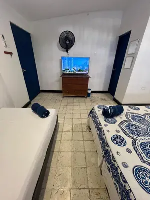 two beds in a room with a flat screen tv at Belcanto Room's in Cartagena de Indias