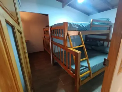 a room with two bunk beds and a doorway at Cabaña El Cangrejo Azul - Blue Crab House in San Onofre