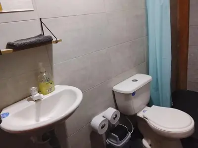 a bathroom with a white toilet and a sink at Cabaña El Cangrejo Azul - Blue Crab House in San Onofre