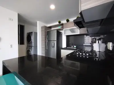 a kitchen with a stove and a refrigerator at Acogedor apartamento en exclusivo barrio de Barranquilla BUENAVISTA - SUNSET VIEW in Barranquilla