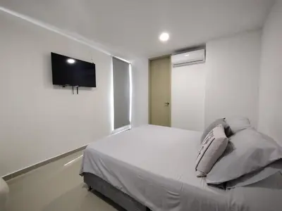 a bedroom with a bed with a tv on the wall at Acogedor apartamento en exclusivo barrio de Barranquilla BUENAVISTA - SUNSET VIEW in Barranquilla