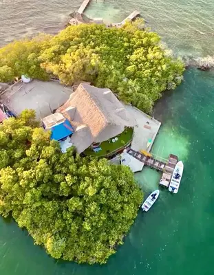 an island with a house and boats in the water at El Arca in Tintipan Island