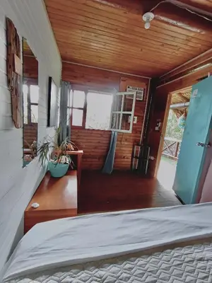 a bedroom with a bed in a wooden house at El Arca in Tintipan Island