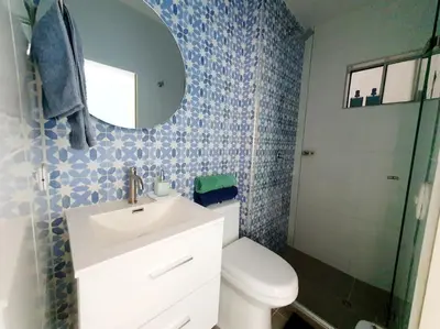 a bathroom with a toilet and a sink and a mirror at Acogedor Apto en piso 22 vista al mar in Cartagena de Indias