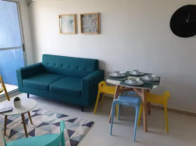 a living room with a couch and a table and chairs at Acogedor Apto en piso 22 vista al mar in Cartagena de Indias