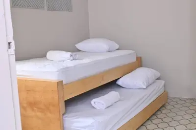 two bunk beds with white sheets and pillows on them at Apartahotel Edificio Baquero x10 Apto 403 in Barranquilla