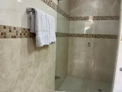 a bathroom with a shower with a white towel at Cabrero, cerca de la Ciudad Amurallada y playa in Cartagena de Indias