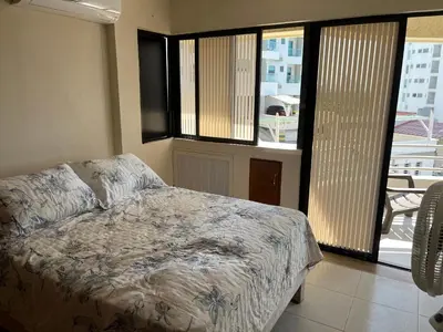 a bedroom with a bed and a view of a balcony at Cabrero, cerca de la Ciudad Amurallada y playa in Cartagena de Indias