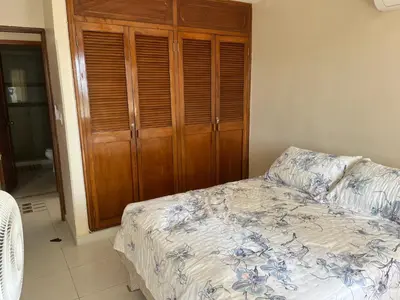 a bedroom with a bed and a wooden cabinet at Cabrero, cerca de la Ciudad Amurallada y playa in Cartagena de Indias