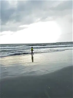 a person walking on the beach near the ocean at Cabaña Maria José in Moñitos