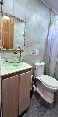 a bathroom with a sink and a toilet and a mirror at Cabaña Maria José in Moñitos