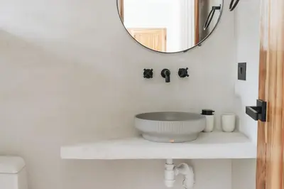 a white bathroom with a sink and a mirror at Gaia Casa de Mar in El Bobo