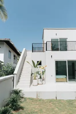 a white house with stairs and potted plants at Gaia Casa de Mar in El Bobo
