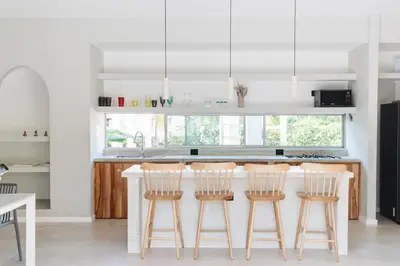a kitchen with a counter with four bar stools at Gaia Casa de Mar in El Bobo