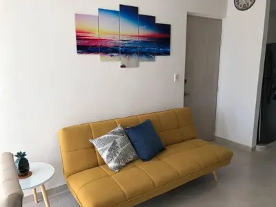 a living room with a couch and a painting on the wall at Acogedor apartamento en Cartagena/asequible in Cartagena de Indias