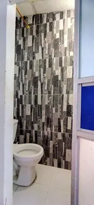 a bathroom with a toilet and a tiled wall at Apartamento Amoblado Confortable in Cartagena de Indias