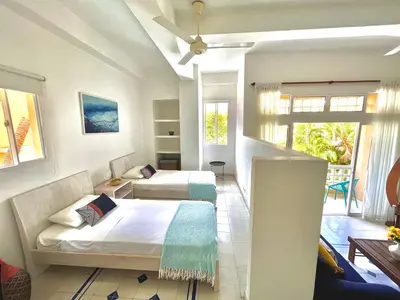 a bedroom with two beds and a balcony at by Calamari Homes - Parque Centenario 202 walled city in Cartagena de Indias