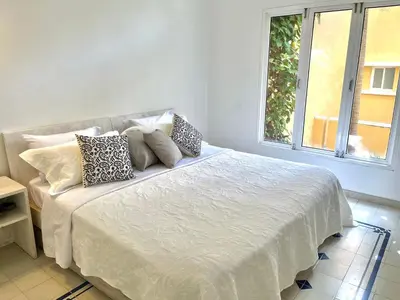 a bedroom with a white bed with pillows and a window at by Calamari Homes - Parque Centenario 202 walled city in Cartagena de Indias