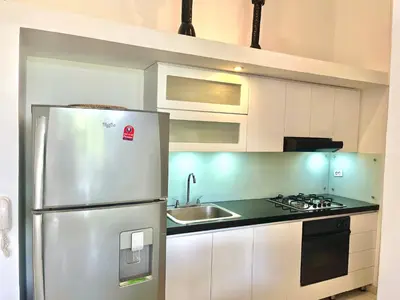 a kitchen with a stainless steel refrigerator and a sink at by Calamari Homes - Parque Centenario 202 walled city in Cartagena de Indias