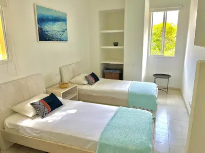 two beds in a room with two windows at by Calamari Homes - Parque Centenario 202 walled city in Cartagena de Indias
