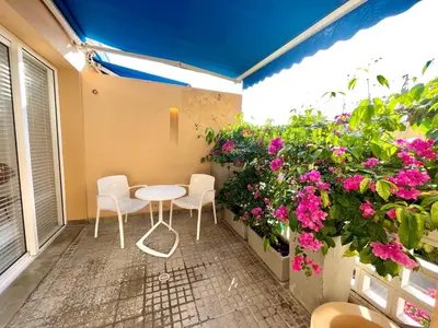 a patio with pink flowers and a table and chairs at by Calamari Homes - Parque Centenario casa 206 walled city in Cartagena de Indias