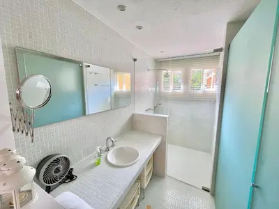 a bathroom with a sink and a shower and a mirror at by Calamari Homes - Parque Centenario casa 206 walled city in Cartagena de Indias