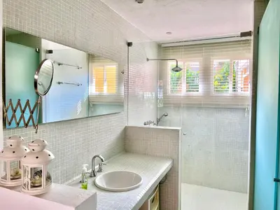 a bathroom with a sink and a glass shower at by Calamari Homes - Parque Centenario casa 206 walled city in Cartagena de Indias