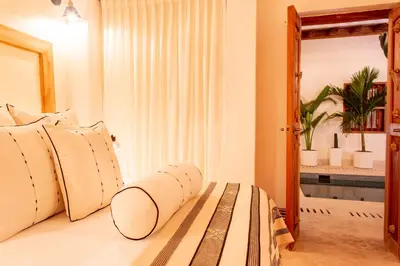 a bedroom with a bed with a wooden frame and a mirror at Palmas de Alba Hotel Boutique in Cartagena de Indias
