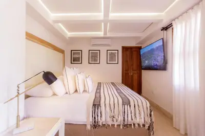a white bedroom with a bed and a desk at Palmas de Alba Hotel Boutique in Cartagena de Indias
