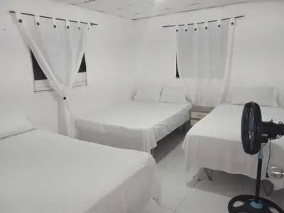 a room with three beds and a camera in it at HOSTAL BARRANQUILLA INN in Barranquilla