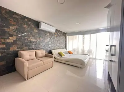a bedroom with a bed and a couch and a chair at Prime Location: Fully Equipped Loft in El Laguito in Cartagena de Indias