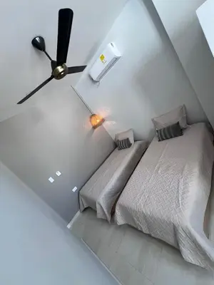 a bedroom with two beds and a ceiling fan at DELAMAR Casa de playa in Coveñas