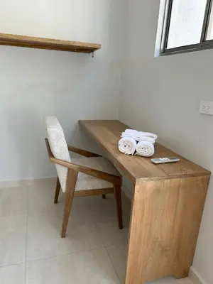 a wooden table with a chair and some towels at DELAMAR Casa de playa in Coveñas