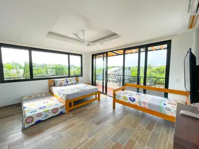 a living room with two beds and large windows at CABAÑA PLAYA MAR in Coveñas