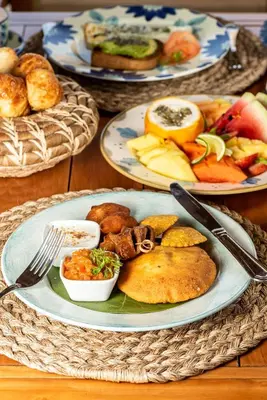 a table topped with plates of food on top at ACASI Rustic Beach in Baru