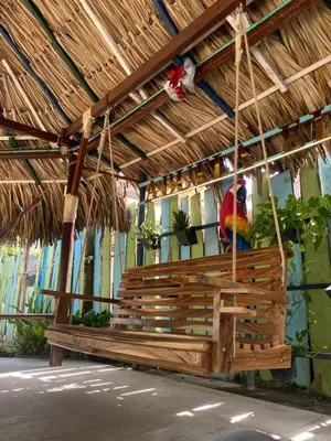 a wooden bench with a parrot sitting on it at Cabaña en Santiago de Tolú. in San Silvestre
