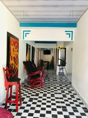 a room with red chairs and a black and white checkered floor at Cabaña en Santiago de Tolú. in San Silvestre