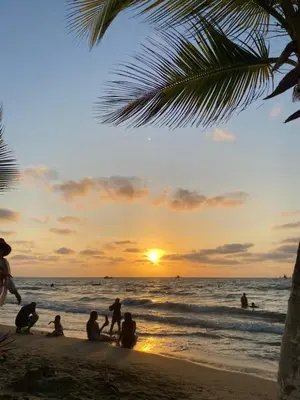 a group of people sitting on the beach at sunset at Cabaña en Santiago de Tolú. in San Silvestre