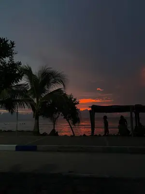two people standing under a canopy on the beach at sunset at Cabaña en Santiago de Tolú. in San Silvestre