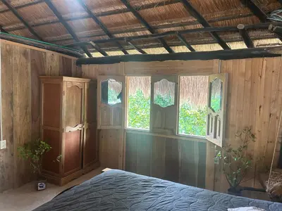 a bedroom with a bed and some windows at Punta Arena EcoHostal & EcoFit in Playa Punta Arena